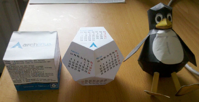 Cubo de comandos, calendario y Tux en papel